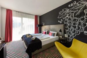 a bedroom with a bed and a yellow chair at Hotel Bonvino Badacsony in Badacsonytomaj +104 photos