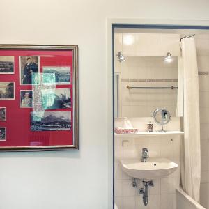 een badkamer met een wastafel en een foto aan de muur bij Hofwiese in Hohenschwangau