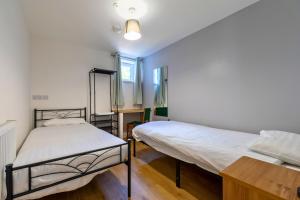 a bedroom with two beds and a table in it at The Elements Residence in Chepstow