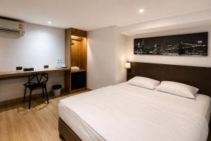 a bedroom with a white bed and a desk at The Blocks Hostel Sukhumvit 10 in Bangkok