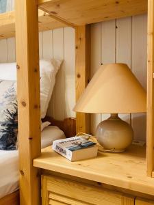 a lamp on a desk with a book and a bed at Waldzauber am See in Clausthal-Zellerfeld