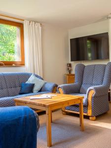 a living room with two chairs and a coffee table at Waldzauber am See in Clausthal-Zellerfeld