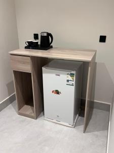 a table with a refrigerator under a table at الباحه للشقق المخدومه in Al Baha