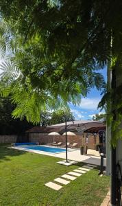 a yard with a swimming pool with an umbrella at Villa Sorella Baranja in Karanac