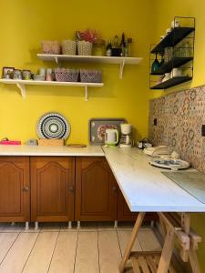 a kitchen with yellow walls and a wooden table at The Stone House in Maronia
