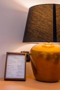 a lamp and a sign sitting on a table next to a lamp gmaxwell gmaxwell gmaxwell at ALMA ROOM in Santa Maria Capua Vetere +19 photos