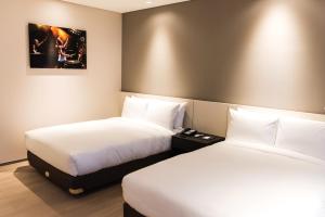 En eller flere senge i et værelse på Hotel Nanta Jeju