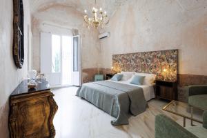 a bedroom with a large bed and a chandelier at Grotta Sancta Suite&SPA in Gallipoli +39 photos