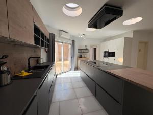a large kitchen with black counter tops and wooden counters at Seventies - Private Pool - 16 Guests - Quarteira in Quarteira