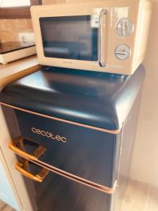 a microwave sitting on top of a refrigerator at Buhardilla con encanto in Ontinyent