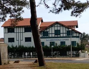 a building with a tree in front of it at Le Carrefour des Landes in Mimizan-Plage