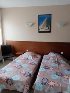 a hotel room with a bed and a picture on the wall at Le Carrefour des Landes in Mimizan-Plage