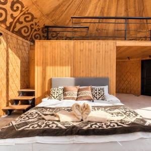 a woman laying on a bed in a room at Ayu Eco Hotel in Karakol