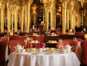 a dining room with a table with cups and plates of food at Hotel Cafe Royal in London +271 photos