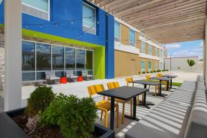 a patio with tables and chairs and a building at Home2 Suites By Hilton Springfield in Springfield