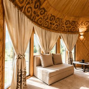 a living room with a couch in front of a window at Ayu Eco Hotel in Karakol