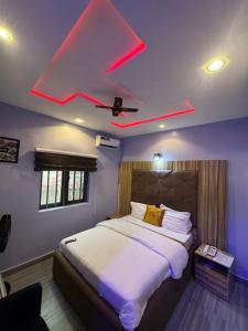 a bedroom with a large bed with a red ceiling at Clisamnoris Hotel limited in Diobu