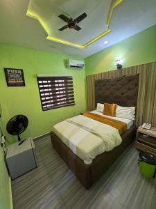 a bedroom with a bed and a ceiling fan at Clisamnoris Hotel limited in Diobu