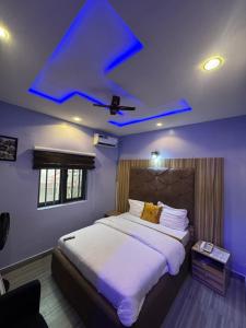 a bedroom with a large bed with a blue ceiling at Clisamnoris Hotel limited in Diobu