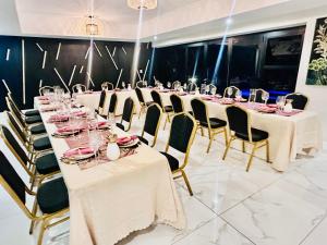 a long table with white tablecloths and chairs and glasses at H & H Boutique & SPA in Roodepoort
