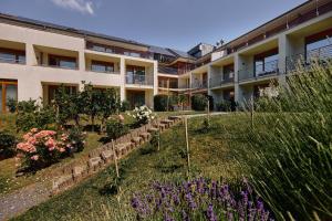 a garden in front of a building with flowers at Hotel Bonvino Badacsony in Badacsonytomaj