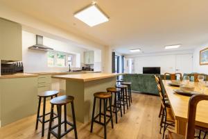 a kitchen with a long bar with stools at The Elements Residence in Chepstow