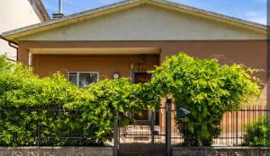 a house with a fence and trees in front of it at stanza a casa marina in Rosolina