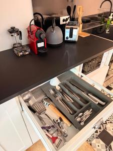 a drawer withrenches and other kitchen utensils in it at Studio duplex avec spa et cour privée in Bonnelles