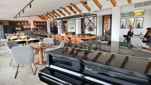 a restaurant with a piano in the middle of a room at Nidum - Šariš Park Hotel & Wellness in Prešov