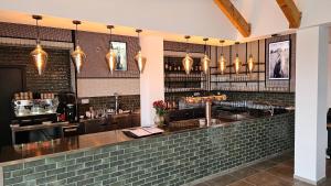 a bar in a restaurant with a brick wall at Nidum - Šariš Park Hotel & Wellness in Prešov
