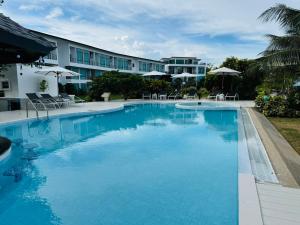 a large swimming pool in front of a hotel at The Beach Resort & Residence - SHA Plus in Pathiu