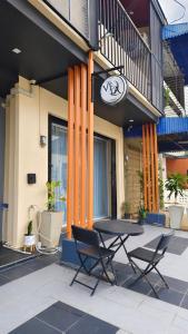 a table and chairs in front of a building at Vela House Hatyai in Hat Yai