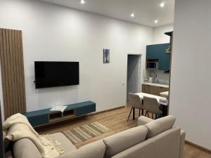 a living room with a couch and a tv on a wall at Апарт-готель номер 303 in Truskavets