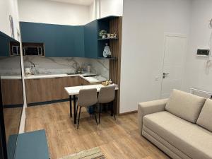 a living room with a couch and a table and a kitchen at Апарт-готель номер 303 in Truskavets