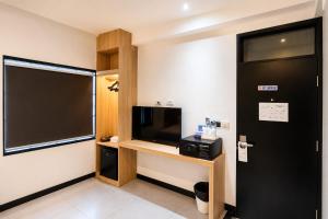 a room with a flat screen tv and a desk at The Blocks Hostel Sukhumvit 10 in Bangkok