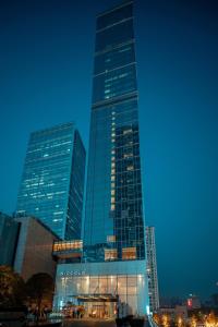 a tall glass building with lights on in a city at Niccolo Chengdu in Chengdu
