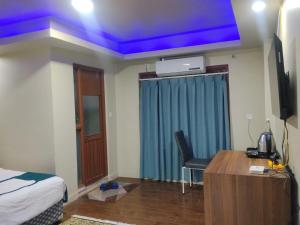 a bedroom with a bed and a desk and a blue ceiling at Anamnagar Union House in Kathmandu