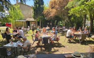 a group of people sitting at tables in a yard at Hostal Restaurante Las Cavenes Del Cabaco in El Cabaco +7 photos