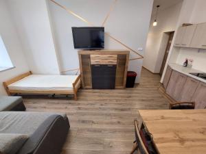 a room with a tv and a couch and a table at Apartamenty Floris Bochnia in Bochnia
