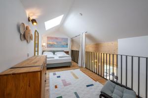 a attic bedroom with a bed and a balcony at Wiesenblick Residences - by myNests in Haus im Ennstal