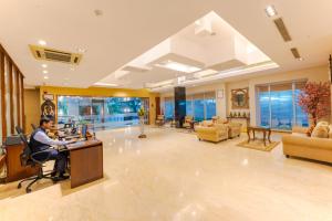 a man sitting at a desk in a lobby at MGM Mark Whitefield in Bangalore