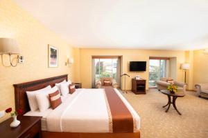 a hotel room with a large bed and a living room at MGM Mark Whitefield in Bangalore +48 photos
