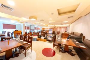 a restaurant with wooden tables and chairs at MGM Mark Whitefield in Bangalore
