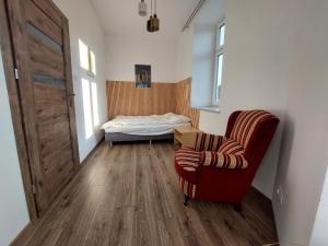 a room with a bed and a chair and a bedroom at Apartamenty Floris Bochnia in Bochnia
