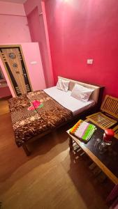 a small bedroom with a bed and a table at Hotel Ashirwad in Chhatarpur