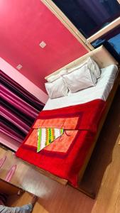 a bed with a red and red blanket on it at Hotel Ashirwad in Chhatarpur +7 photos