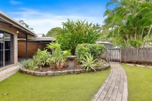 a garden with grass and plants in a house at Green Cottage Trinity Beach Pet friendly BBQ in Trinity Beach