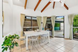 a dining room with a white table and chairs at Green Cottage Trinity Beach Pet friendly BBQ in Trinity Beach