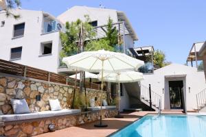 a pool with an umbrella next to a building at September15 Suites- Meganisi in Meganisi