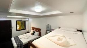 a bedroom with two beds with white sheets at Pilot Hotel in Amandiego +291 photos
